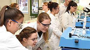 Gruppe junger Wissenschaftlerinnen vor einem Laborgerät