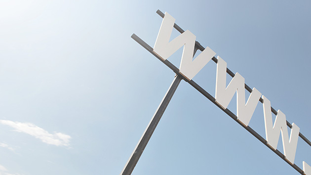 Symbolic image for the Web Desk. View from below into blue sky on a metal construction with three big W letters.