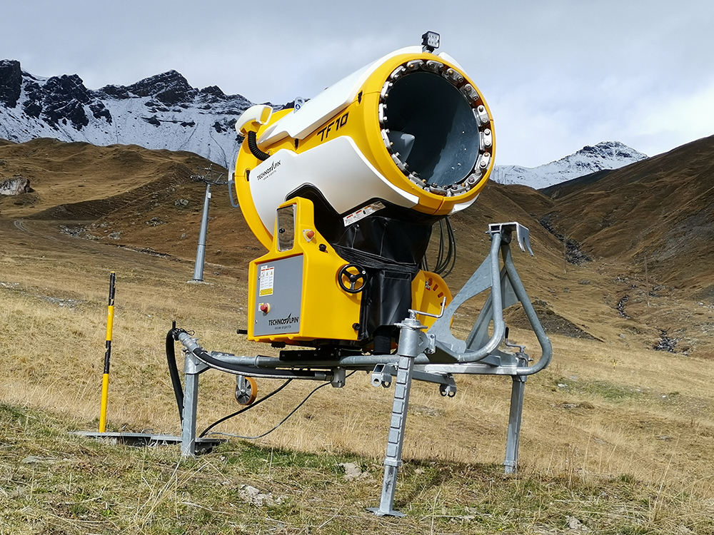 Schneekanone auf braunem Alpengrasland Schneekanone auf braunem Alpengrasland