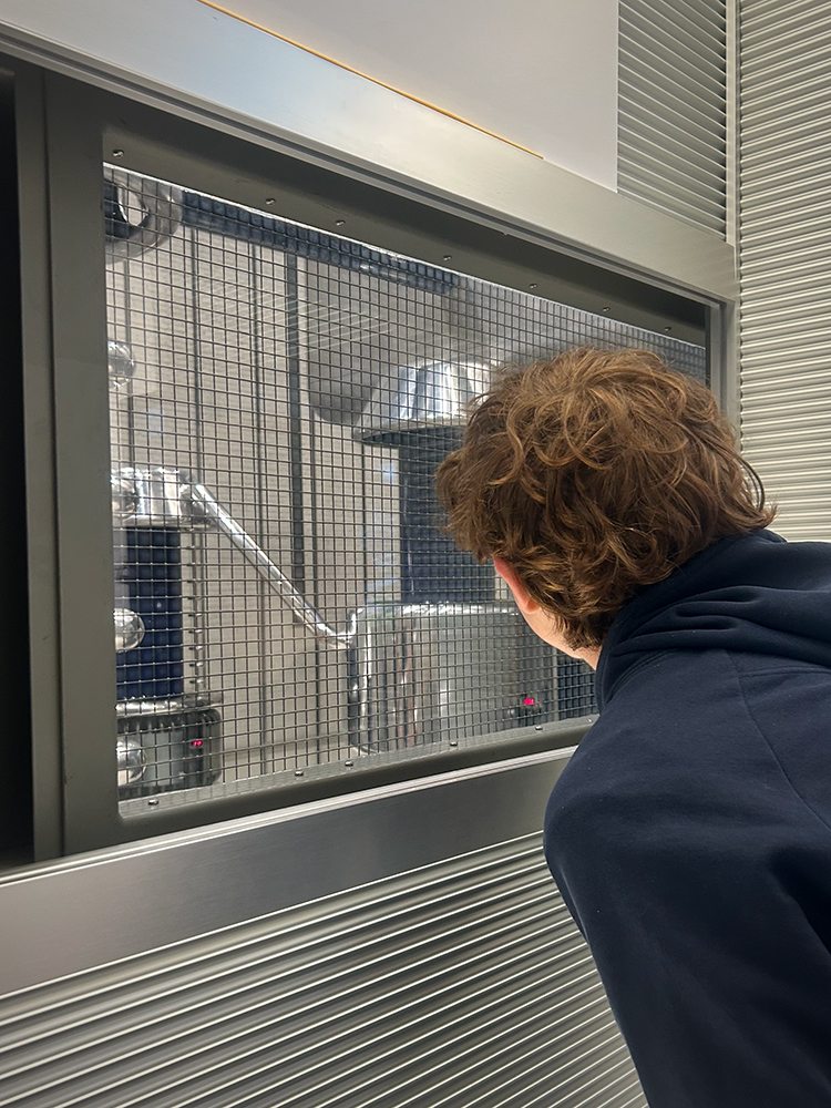 Kasimir blickt durch ein Fenster in den Bereich, in dem Neutronen erzeugt werden. Kasimir blickt durch ein Fenster in den Bereich, in dem Neutronen erzeugt werden.