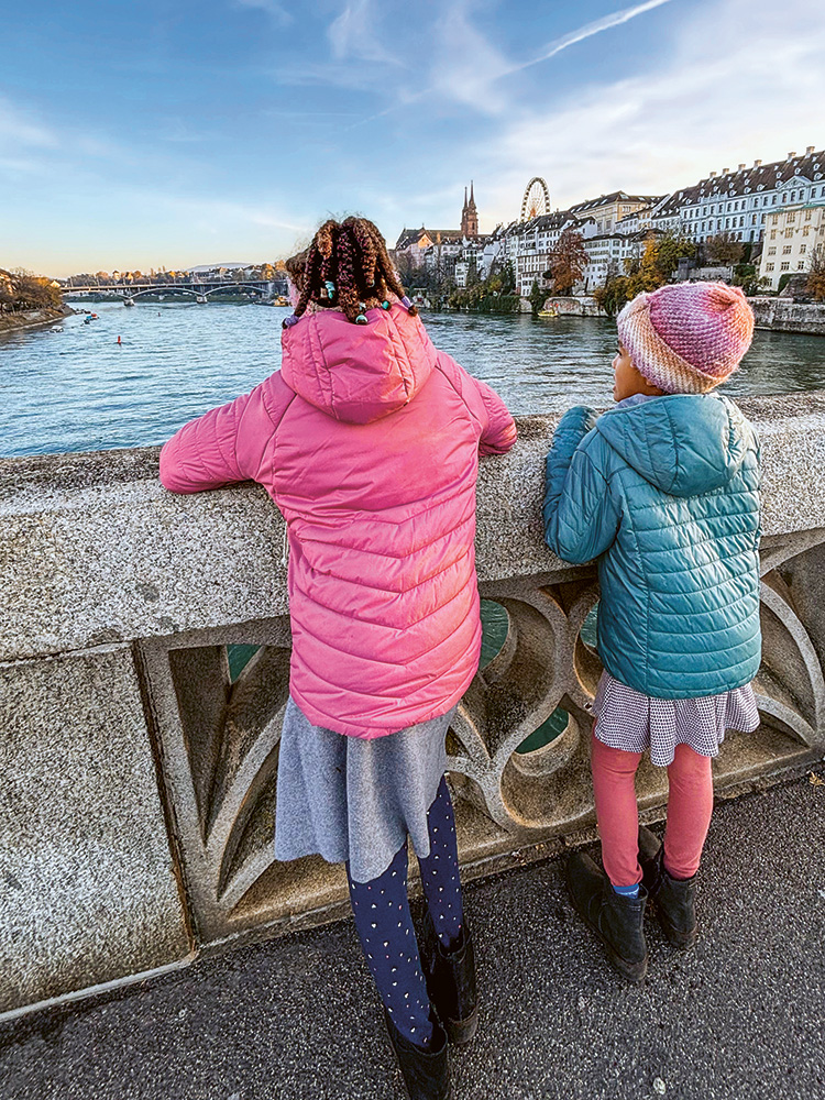 Two children on the bridge "Mittlere Brücke" in Basel with a view of the Rhine and the Basel Minster Two children on the bridge "Mittlere Brücke" in Basel with a view of the Rhine and the Basel Minster