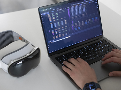 view of the laptop screen with code, the XR glasses next to the laptop view of the laptop screen with code, the XR glasses next to the laptop