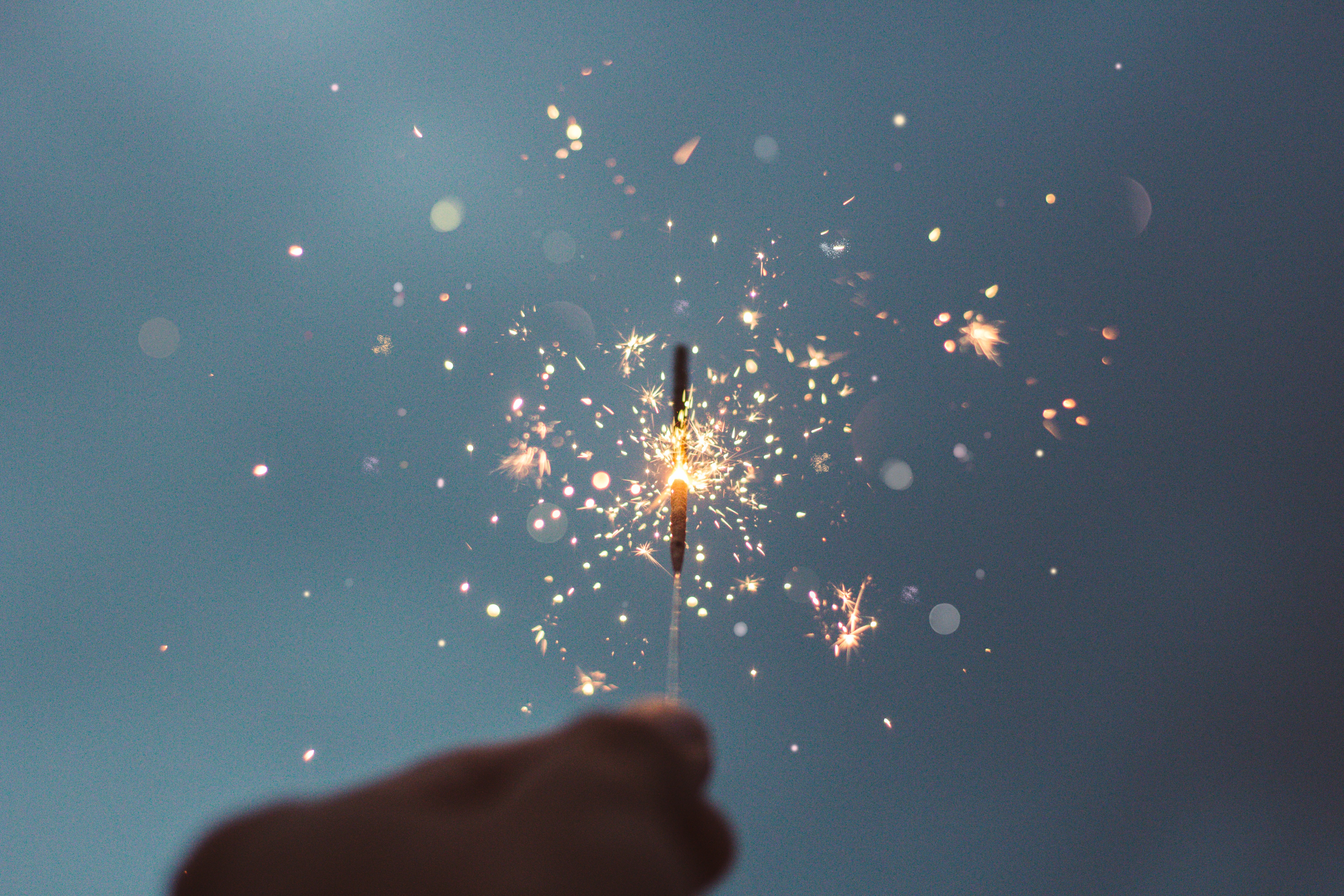 Person holding lighted sparklers Person holding lighted sparklers