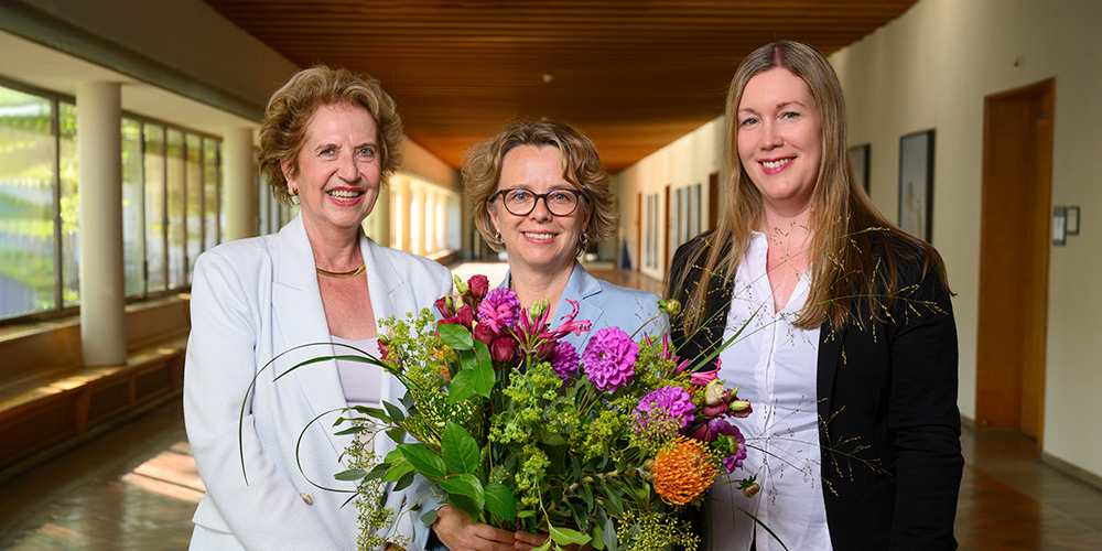 Daniela Thurnherr Keller mit Blumenstrauss, flankiert von Andrea Schenker-Wicki und Christine Meyer Richli