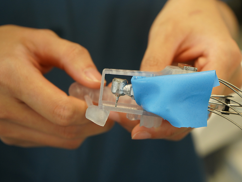 Hände halten den Dentalroboter mit einer Zahnschiene aus Kunststoff Hände halten den Dentalroboter mit einer Zahnschiene aus Kunststoff