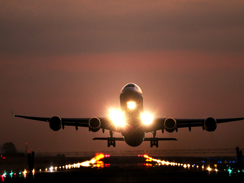 airplane lifting off at dusk