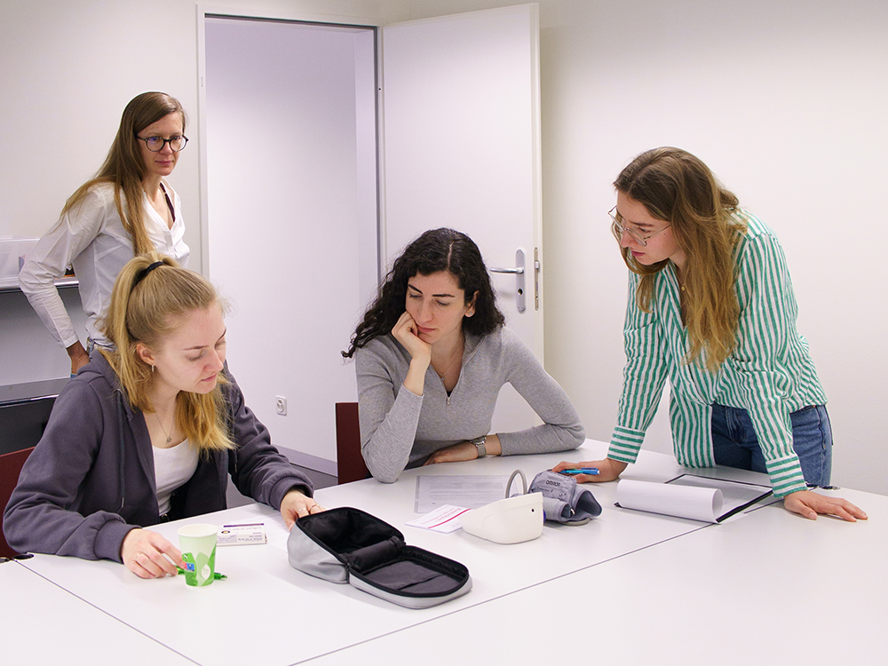 Vier Studierende arbeiten in einem Beratungsraum der Simulationsapotheke gemeinsam an einer Aufgabe. Vier Studierende arbeiten in einem Beratungsraum der Simulationsapotheke gemeinsam an einer Aufgabe.