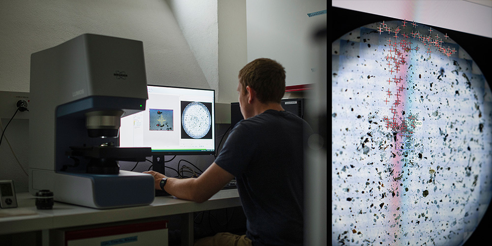 Sebastian Rieder sits at a screen, next to him a microscope. On the screen, dots are marked with red crosses Sebastian Rieder sits at a screen, next to him a microscope. On the screen, dots are marked with red crosses