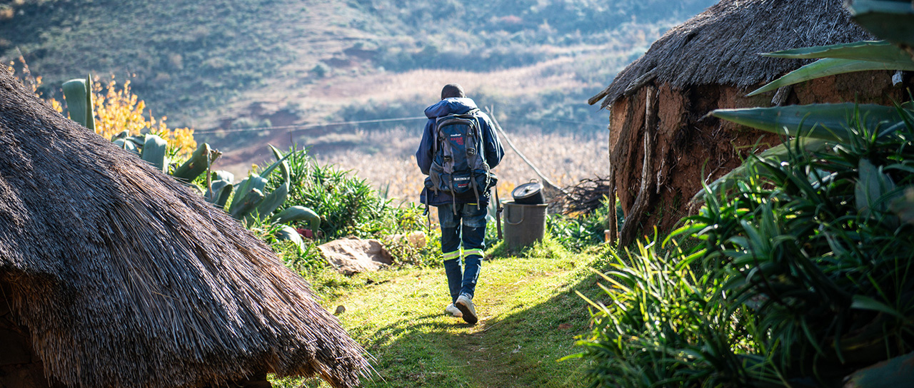 Mann mit Rucksack im ländlichen Lesotho