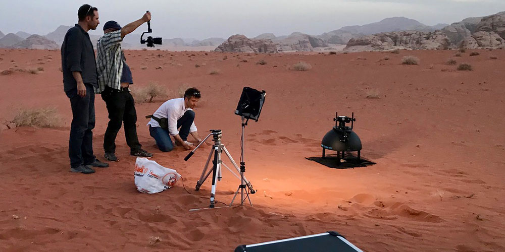 Vorbereitung einer Aufnahme mit dem Broncolor Scope D50: Dr. Peter Fornaro (in weiss) in der Region Wadi Rum nahe der Felsenstadt Petra in Jordanien; ein Filmteam hält den Vorgang fest. (Foto: zvg)