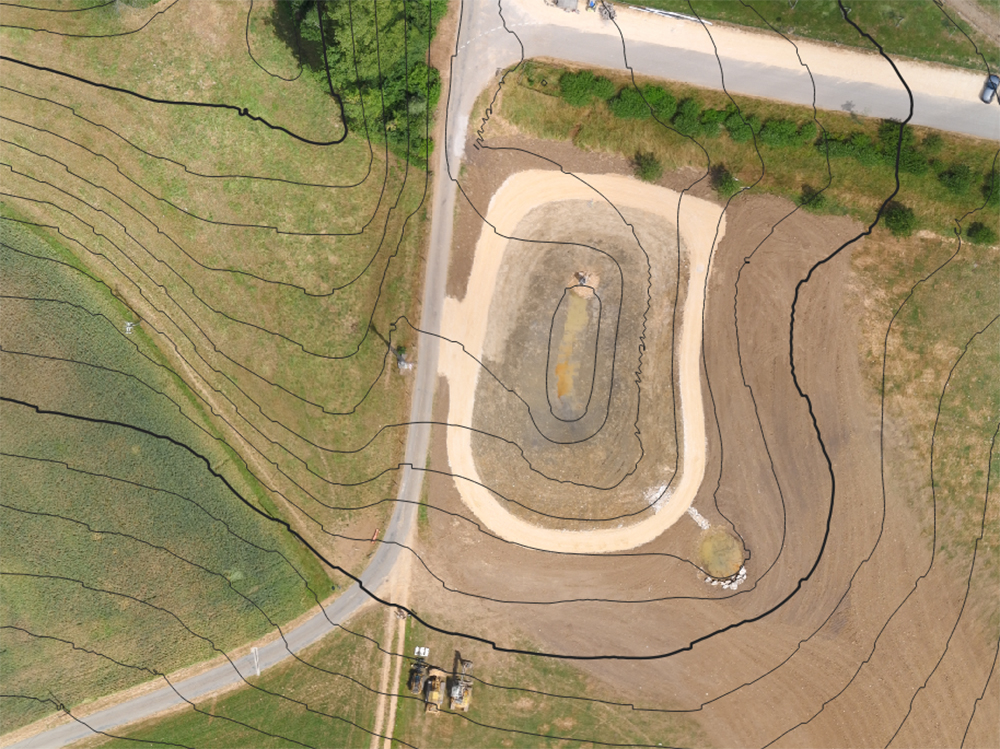 A drone image shows a map of the terrain with the excavated pond bed. A drone image shows a map of the terrain with the excavated pond bed.