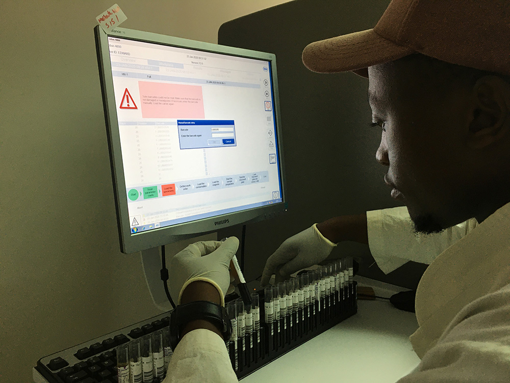 Labortechniker mit Blutproben vor einem Computer Labortechniker mit Blutproben vor einem Computer