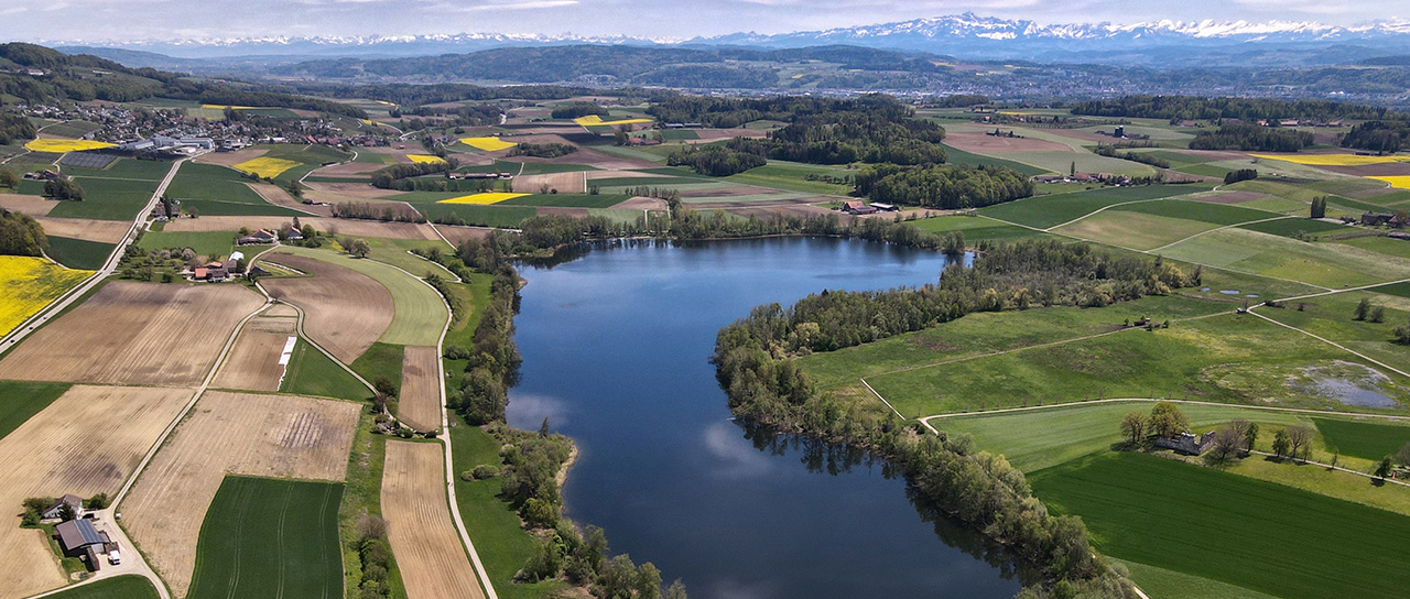 aerial view of a small lake with agricultural fields close by