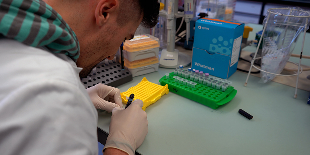 Researcher in the lab labeling Eppendorf tubes