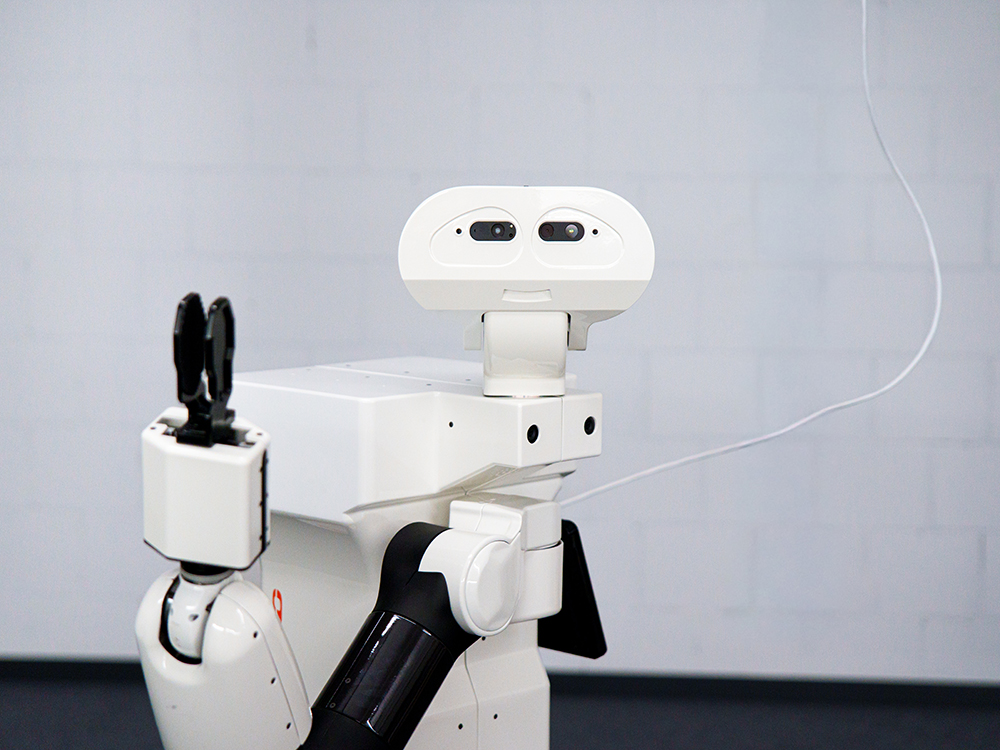 Nahaufnahme eines weissen Roboters mit Kamerasensoren und Greifarm. Nahaufnahme eines weissen Roboters mit Kamerasensoren und Greifarm.