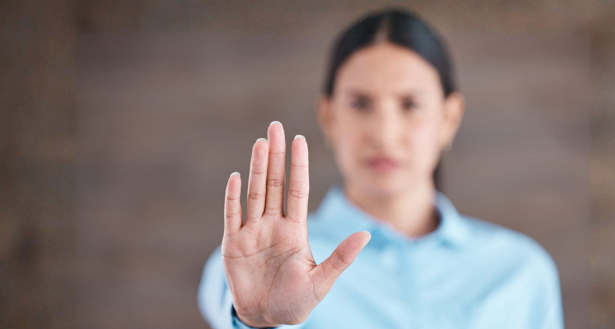 Eine Person hält die Hand ausgestreckt als Zeichen von: Stopp.