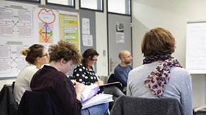 Five workshop participants in front of a flipchart