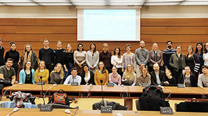 many people posing for a photo in a lecture hall