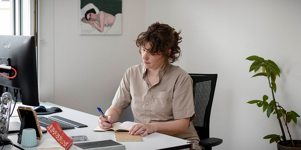 Julia Wartmann sitzt am Schreibtisch in ihrer Wohnung in Zürich. 
