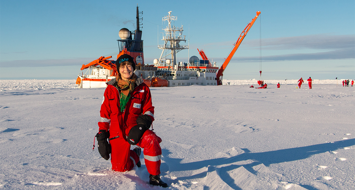 Patricia Holm vor einem Forschungsschiff in der Antarktis