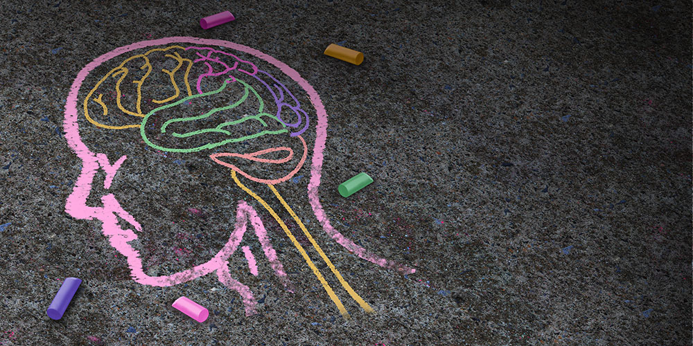Umrisse eines Kopfs und des Gehirns mit Kreide auf Strasse gezeichnet